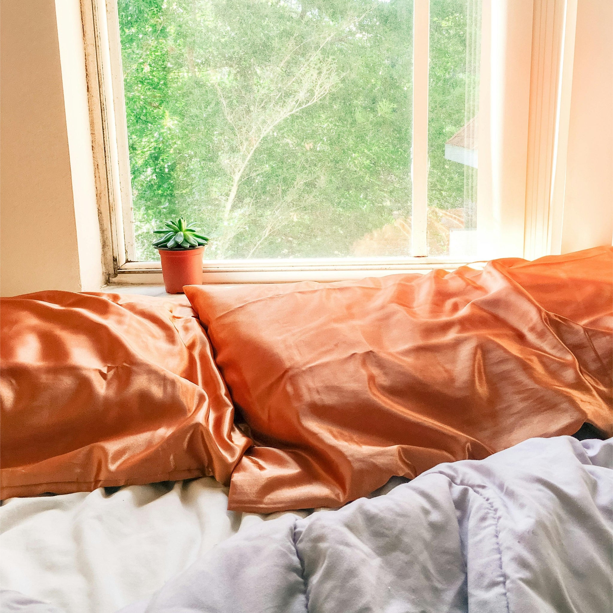 white bed linen near window